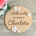 Square wooden newborn name label plaque for baby birth information on a natural plywood background.