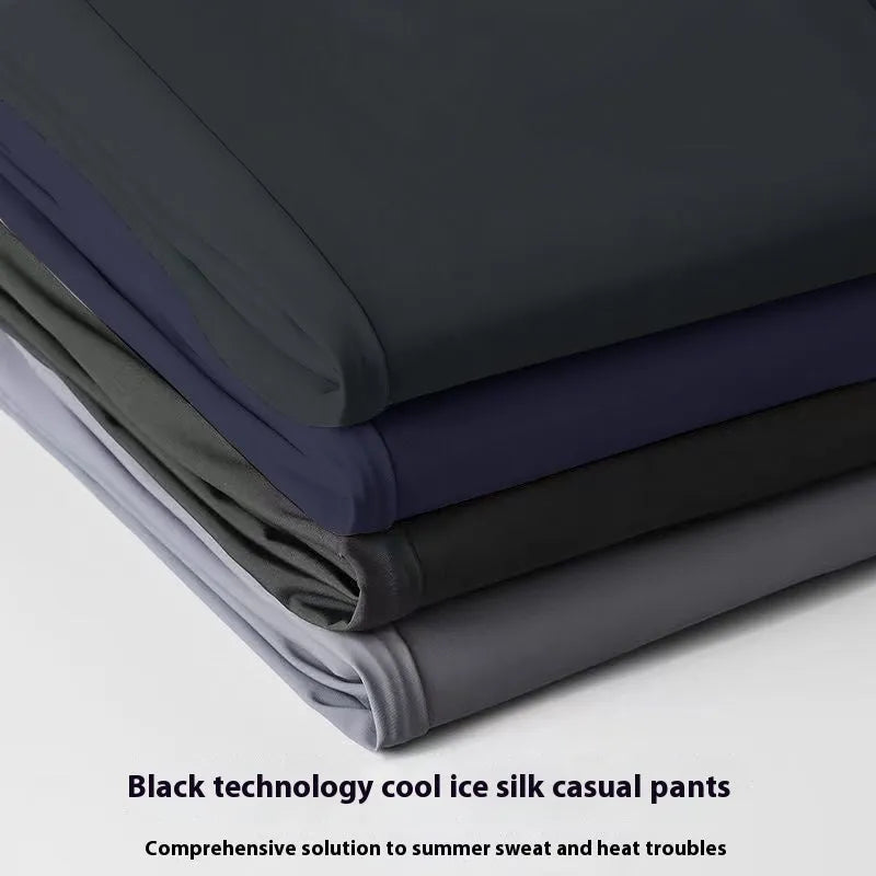 Man wearing loose-fit black ice silk straight-leg trousers with an elastic waistband.
