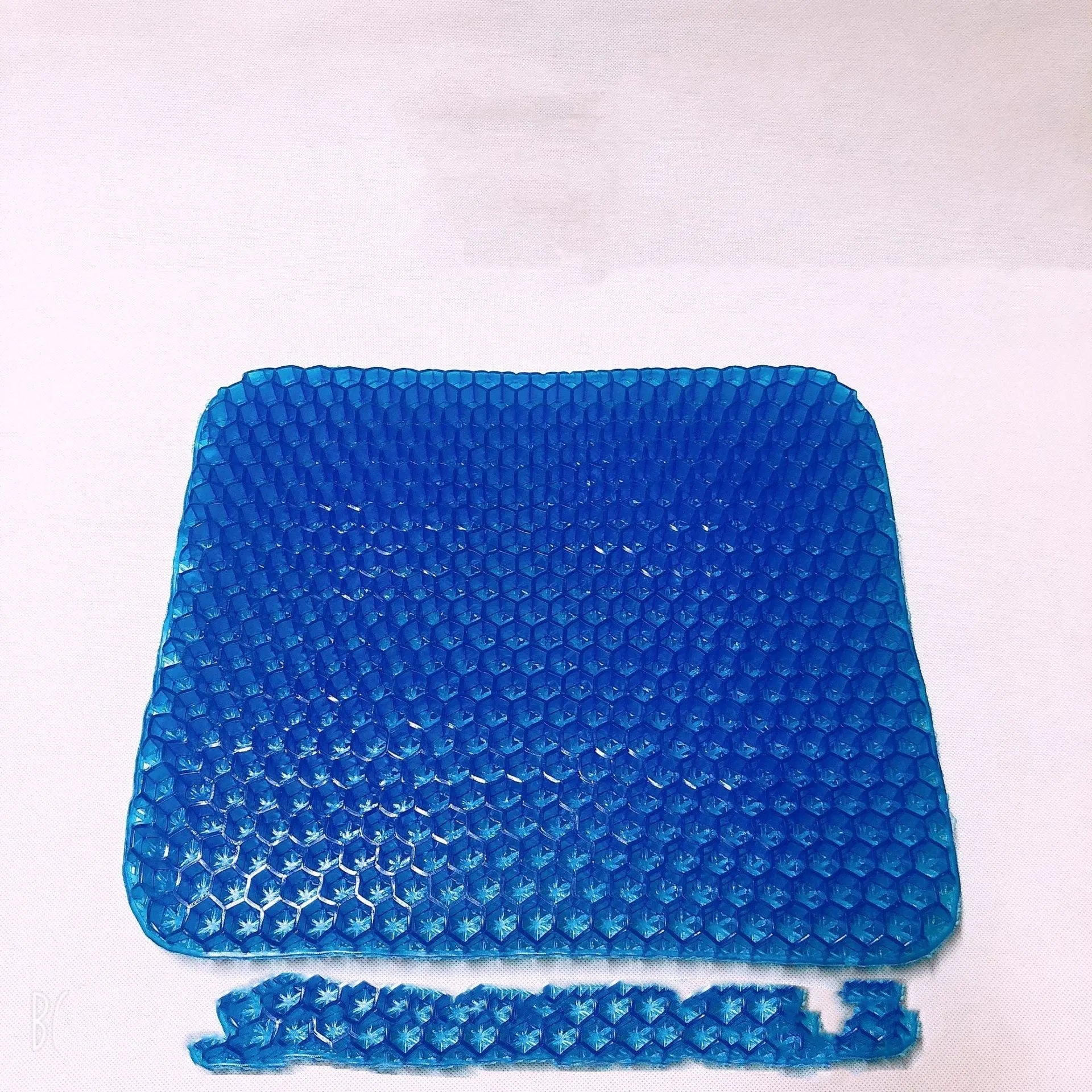 Solid colour gel seat cushion with a honeycomb pattern, shown with its removable PVC cover.