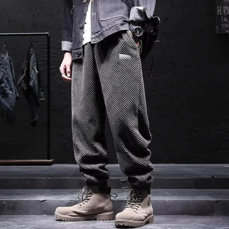 Grey men's sweatpants with ankle ties and a straight leg cut on a neutral background.