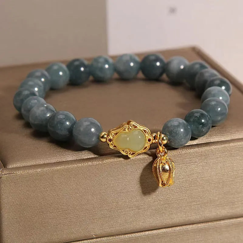 Sky blue natural stone gourd lotus pendant on a women's electroplated bracelet.