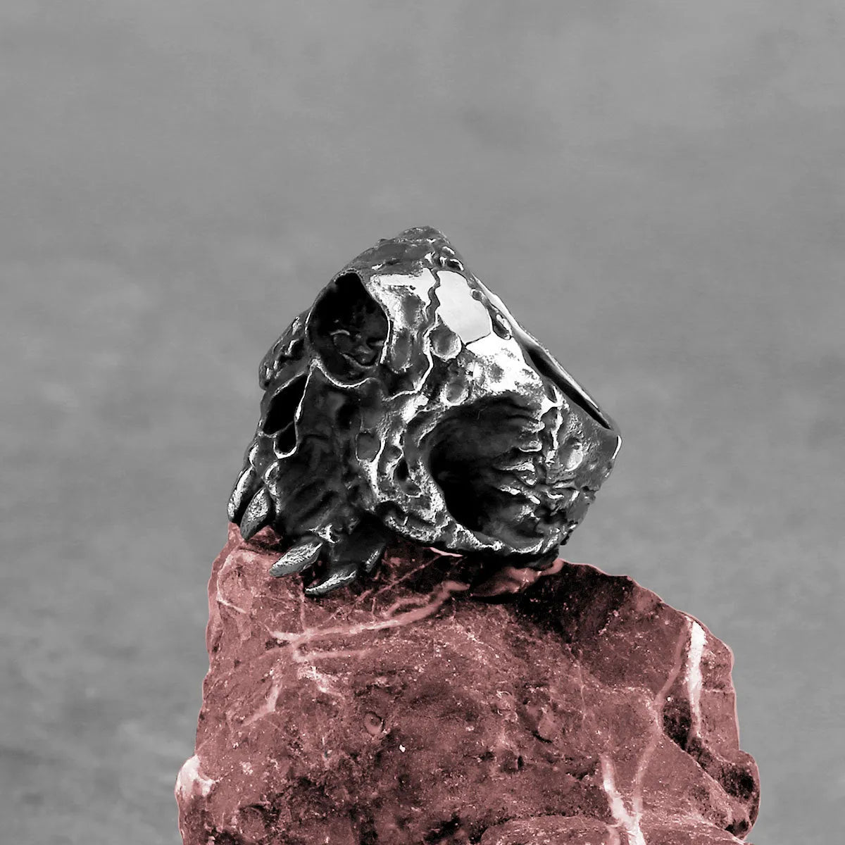 Alloy one-eyed skull ring in a retro electroplated finish, shown on a finger.