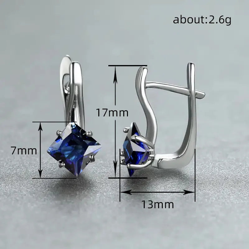 Women's copper earrings with diamond design and inlaid blue zircon stones on a white background.