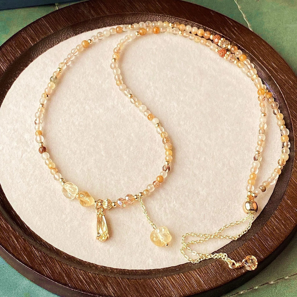 Gold electroplated women's bracelet with three interlinked circles made from natural caramel-coloured citrine and a Saturn decoration.