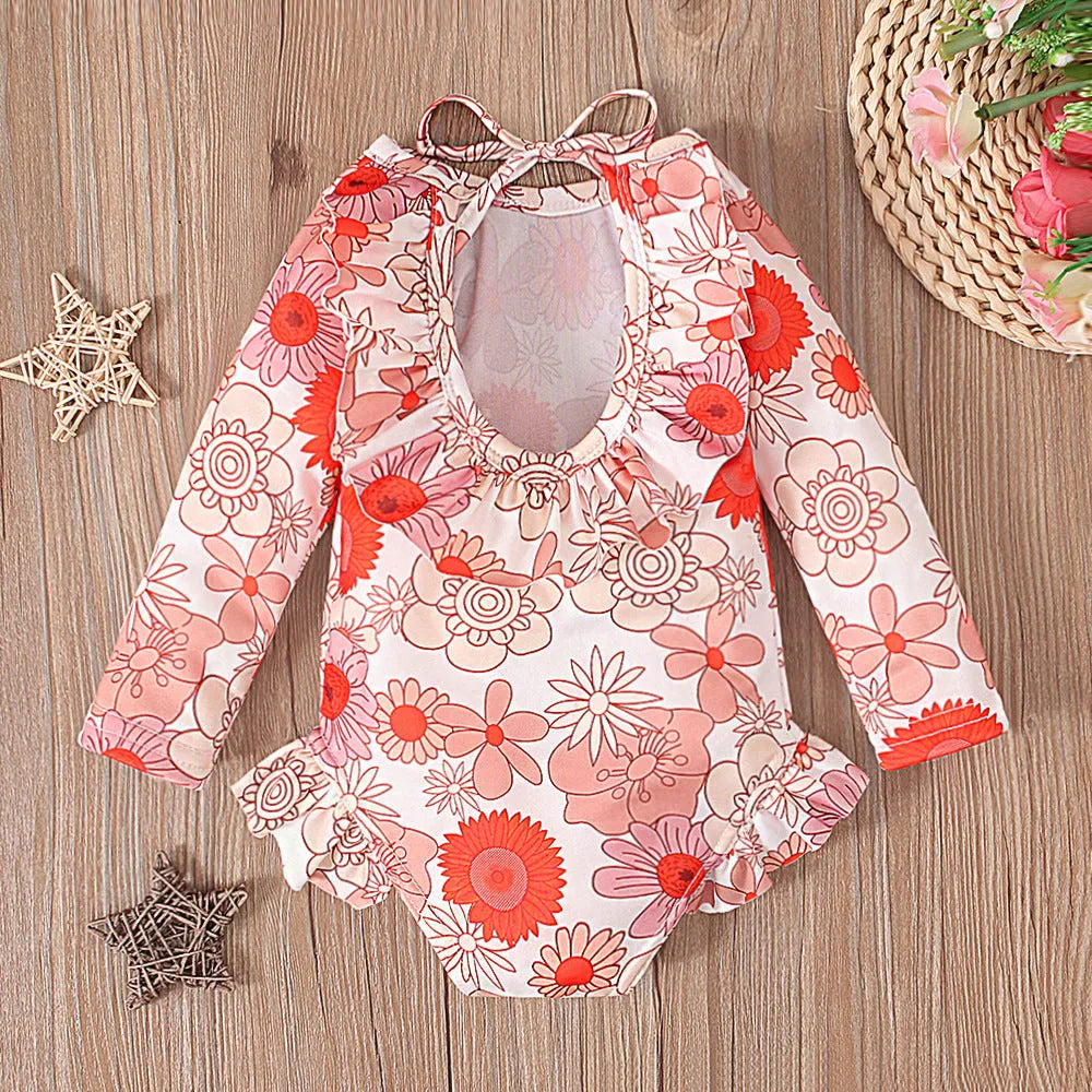 Girl's floral print open back swimsuit in orange, showing crew neck and briefs style.