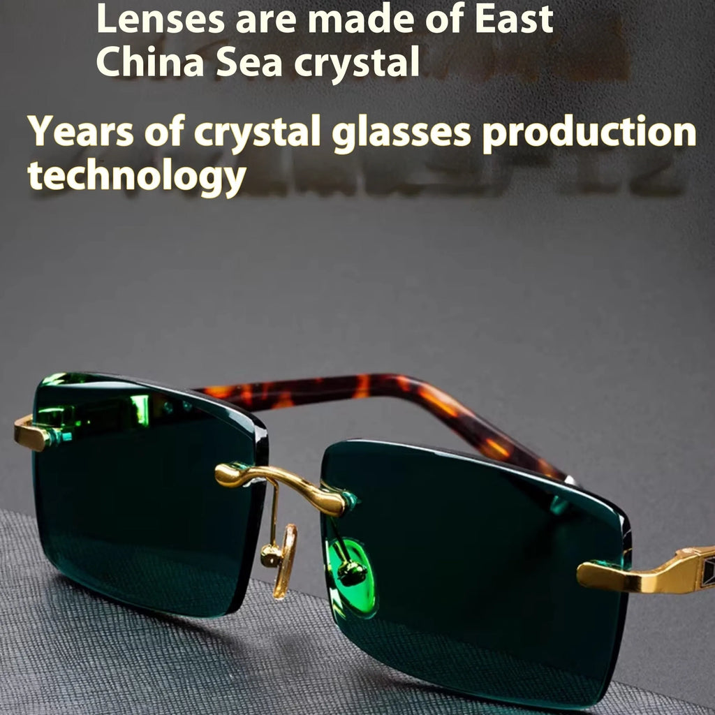 Frameless sunglasses with dark green tinted lenses and a black hard-shell case on a table.