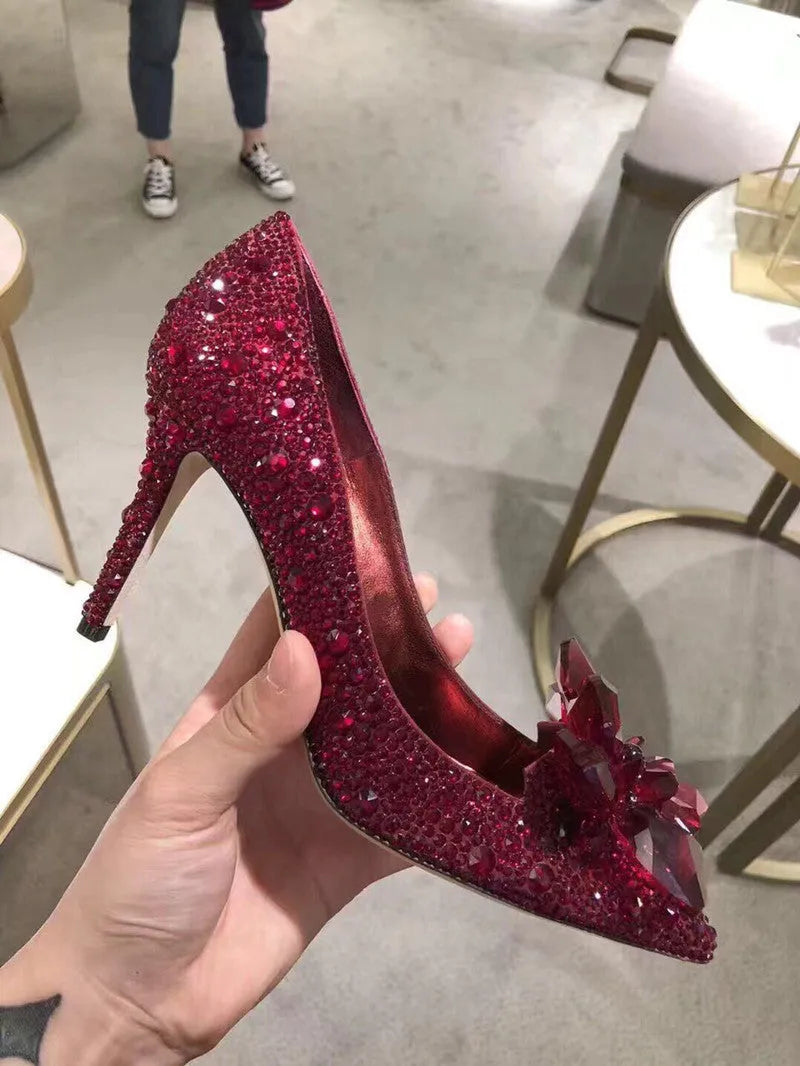 Gold women's stiletto high heels with rhinestone decoration and a pointed toe.