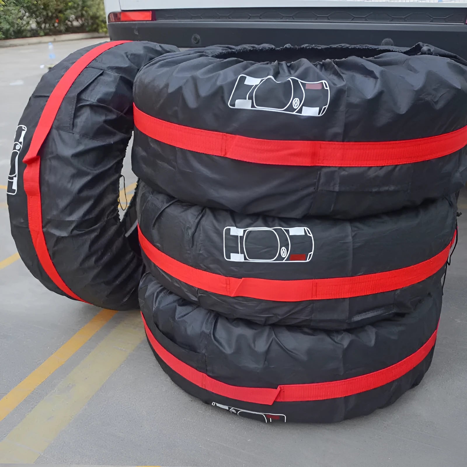 Set of four black Oxford cloth car tyre protective covers laid flat, showing their circular shape and durable fabric texture.