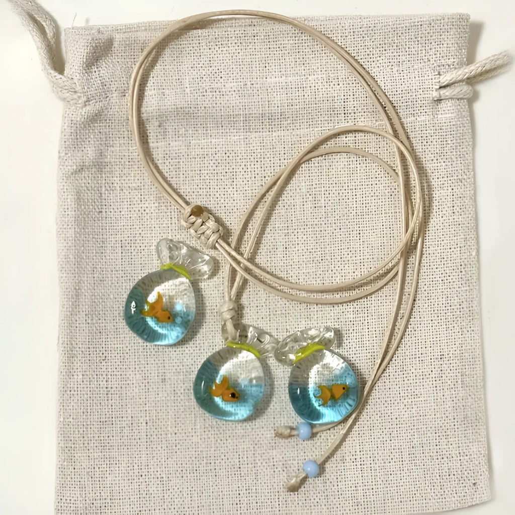 Women's coloured glaze pendant necklace on a braided cotton and linen clavicle chain, showing artisan finish.