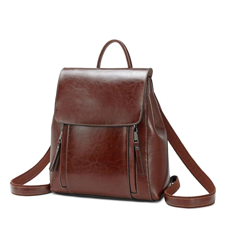 Women's black genuine cowhide leather backpack with stitching detail, shown open to reveal internal zipper and document pockets.