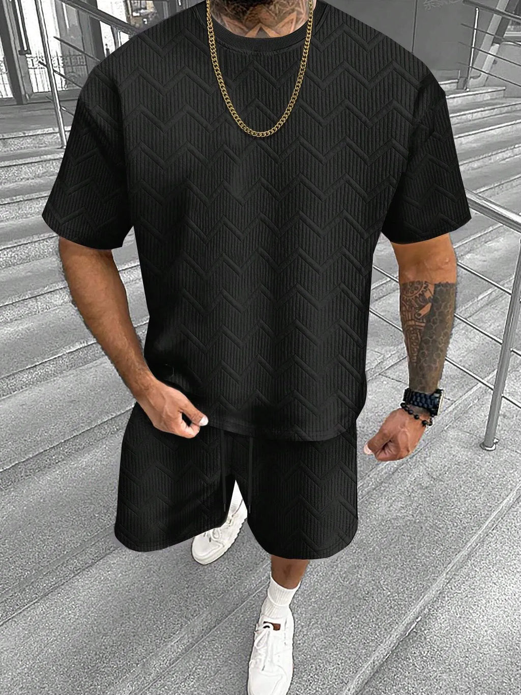 Man wearing a short sleeve printed top with matching shorts from a men's leisure suit set.