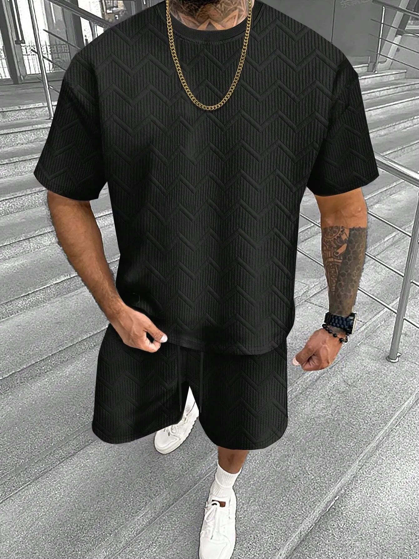 Man wearing a short sleeve printed top with matching shorts from a men's leisure suit set.