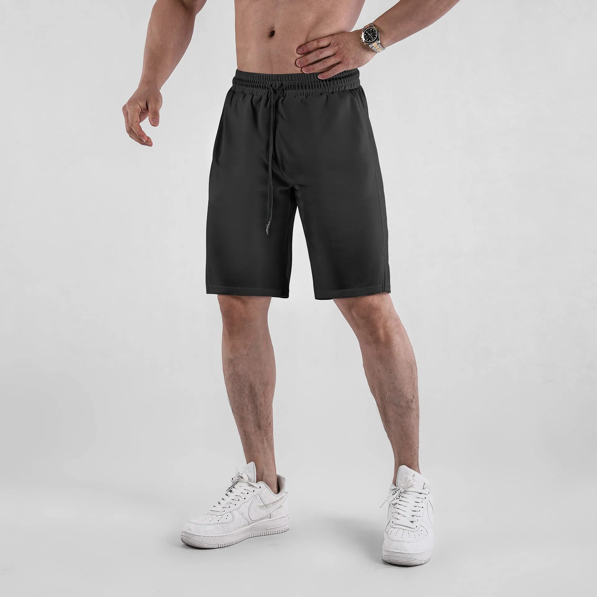 Men's black quick-dry mesh shorts with elastic waistband on a neutral background.