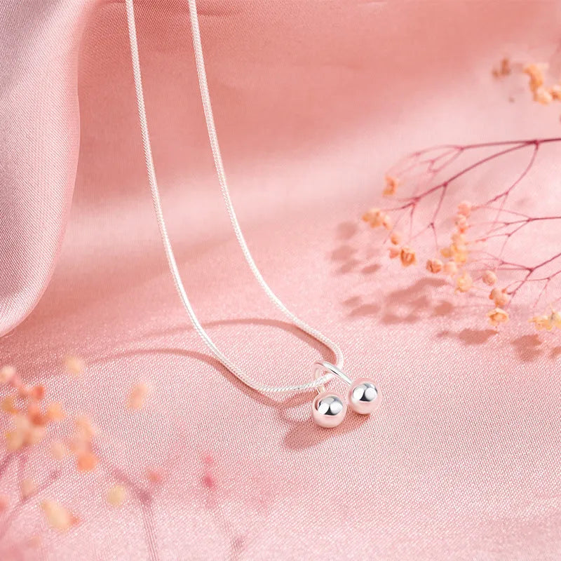 Silver cherry pendant necklace for women on an adjustable snake bones chain.