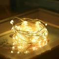 LED copper wire light string with warm white floral-shaped lamps on a dark background