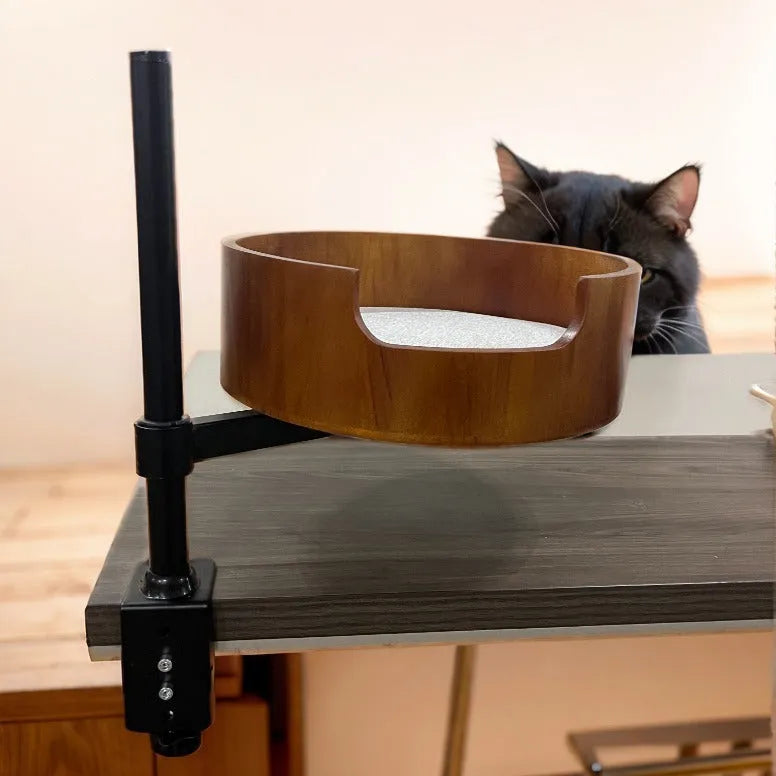 Round desktop suspended cat nest with stainless steel frame in light gray, placed on a wooden desk