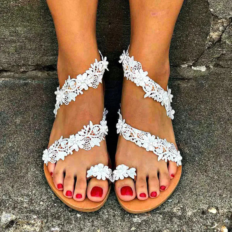White plus-size women's flat shoes with rhinestone and floral decorations on patent leather.
