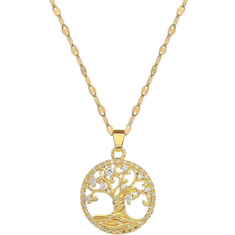 Close-up of a gold necklace with an ornate tree pendant featuring sparkling crystals and a white mother-of-pearl centre, on an adjustable chain.