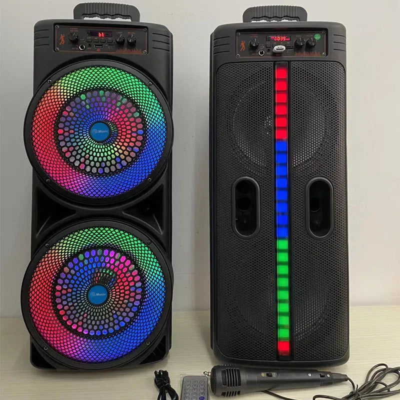 Black portable Bluetooth speaker with double 8-inch speakers, wired microphone, and remote control on a table