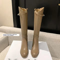 Black cowhide leather lock knight knee-high boots with back zipper and low heel on a neutral background