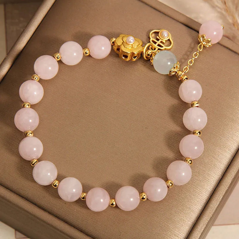Women's pink crystal flower bracelet with a refined grace design on a wrist.