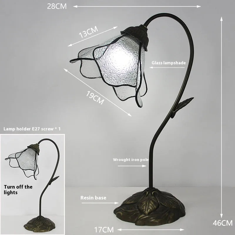 Retro American classical desk lamp with a decorative glass shade on a table.