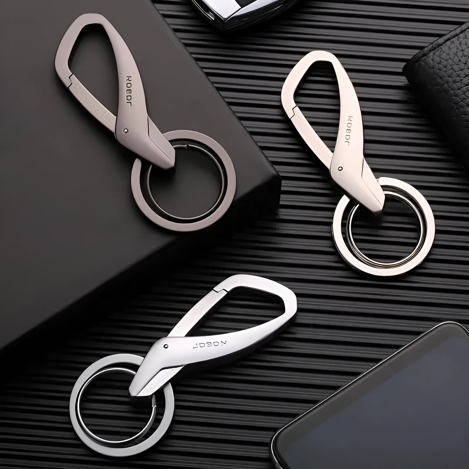 A black zinc alloy double-ring key chain holding a set of keys against a neutral background.