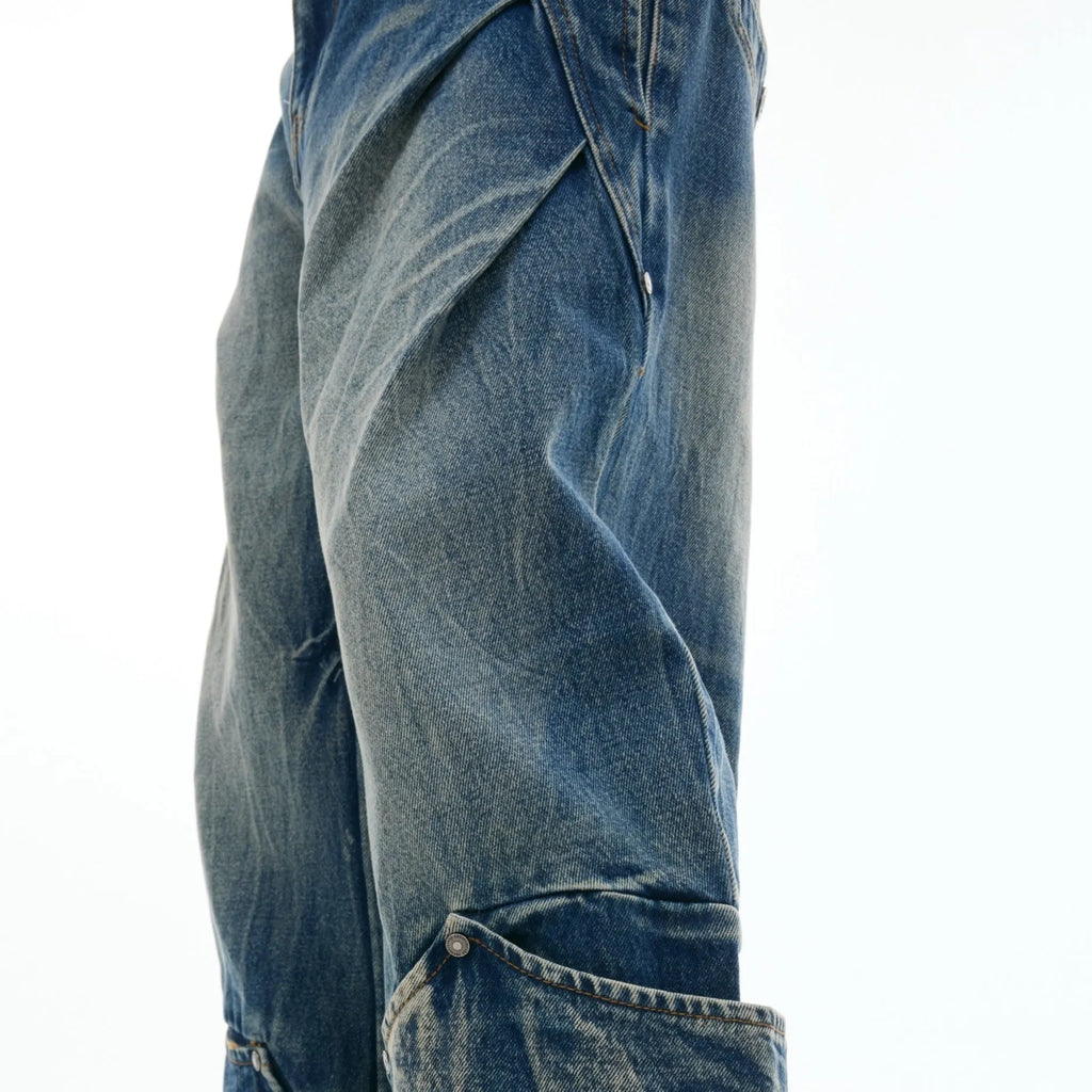 Man wearing verdant blue loose-fit jeans with a burst pattern wash and curved knife cut, front and side view.