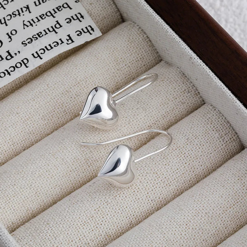 Silver Korean style heart-shaped earrings with a glossy three-dimensional design on a white background.
