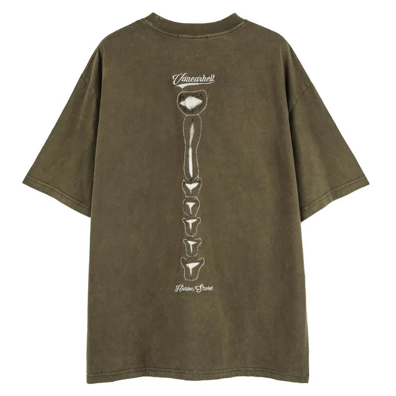 Man wearing a loose brown short sleeve pullover with a large skull and letter graphic print on the front.