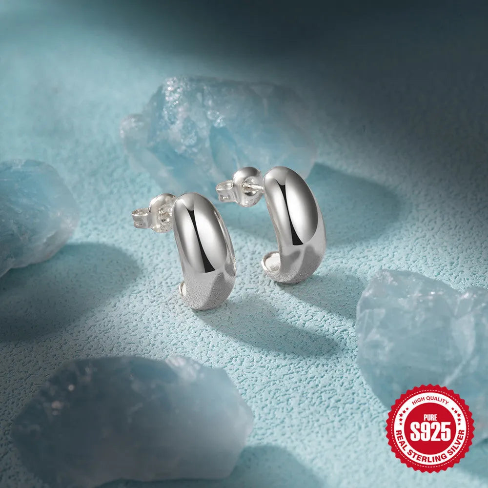 A single C-shaped glossy stud earring made of sterling silver, shown in a gold colour finish.