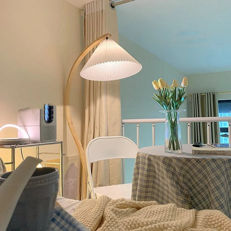 Retro vertical table lamp with a fabric shade in log white, placed on a bedside table.