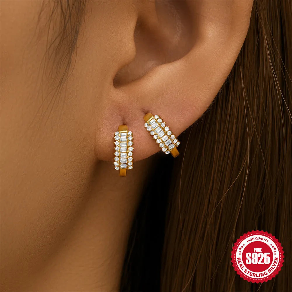A pair of small round geometric stud earrings in sterling silver with an electroplated finish.