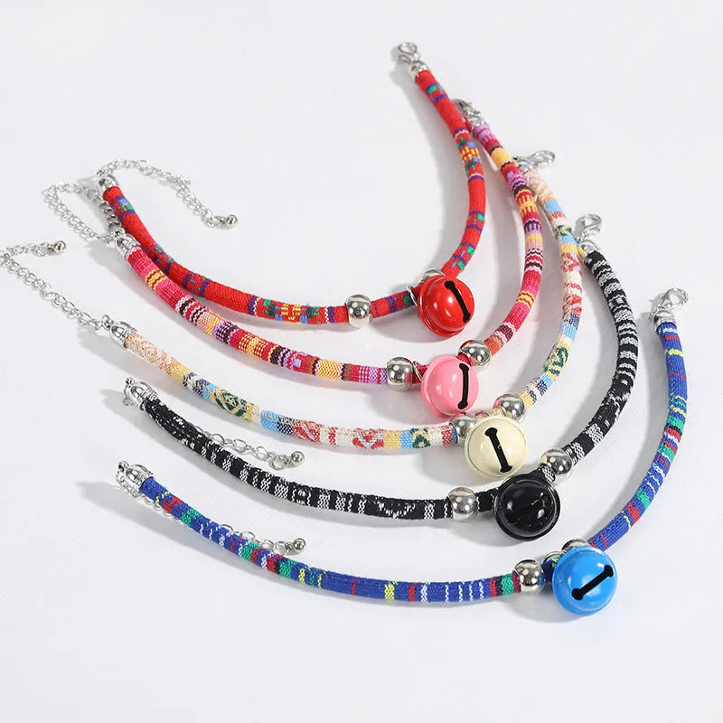 Coloured ethnic style pet collar with a metal bell on a cat or small dog