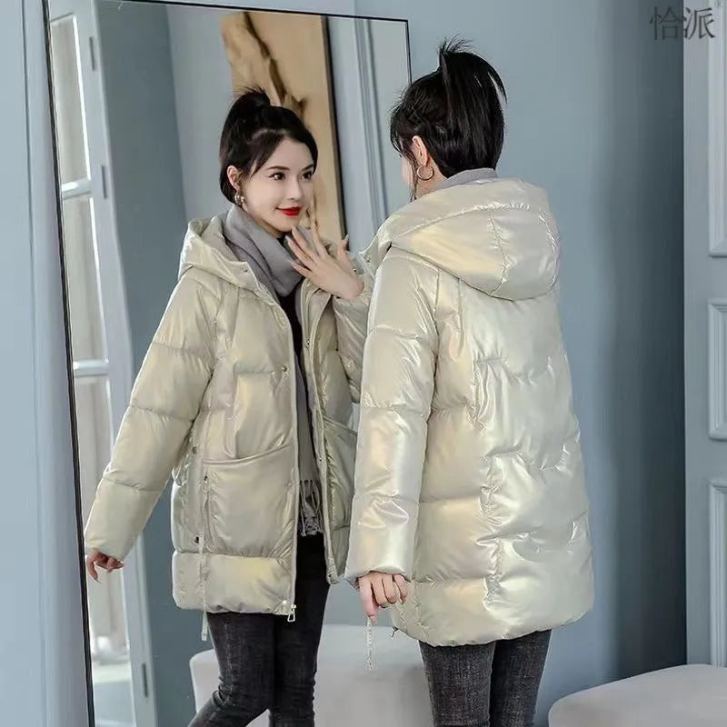 Women's loose-fit green hooded winter jacket with long sleeves on a hanger.