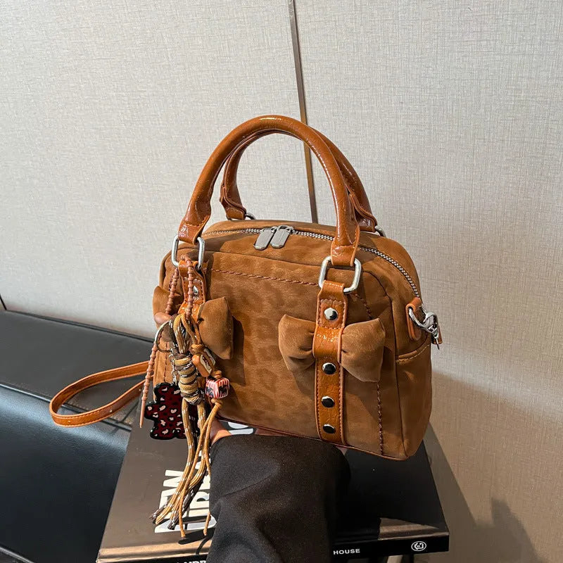 Soft PU pillow bag with crossbody strap, stitching, rivets, and leopard print in brown with pendant
