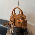 Soft PU pillow bag with crossbody strap, stitching, rivets, and leopard print in brown with pendant