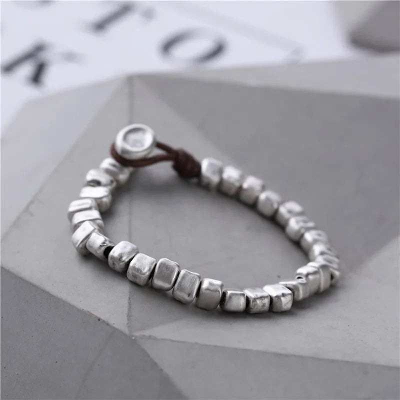 Handmade women's bracelet with irregular silver square and wood on a black elastic band.