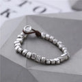 Handmade women's bracelet with irregular silver square and wood on a black elastic band.