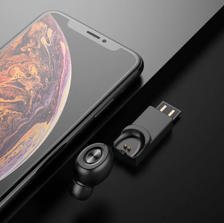 True wireless Bluetooth headset on magnetic car charging base, black colour, with silicone ear caps