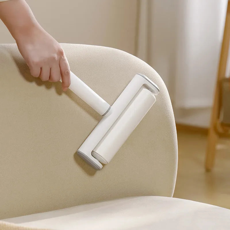Lint remover roller pet tool with handle and four replacement paper sticks for removing cat hair.