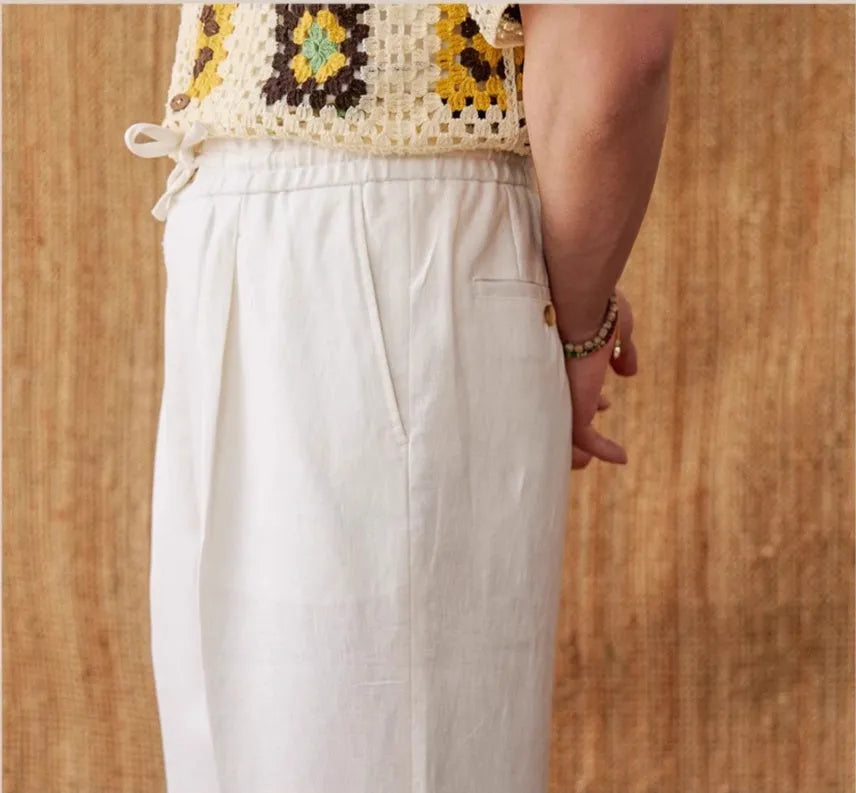 Navy blue linen straight-leg trousers with a high elasticated waistband laid flat.