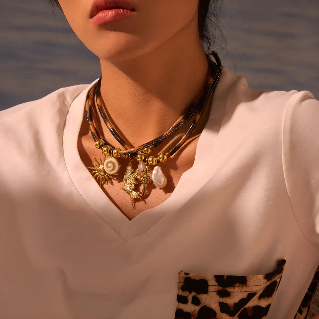 Geometric stainless steel necklace with leopard leather accents on pendant and gold-plated chain