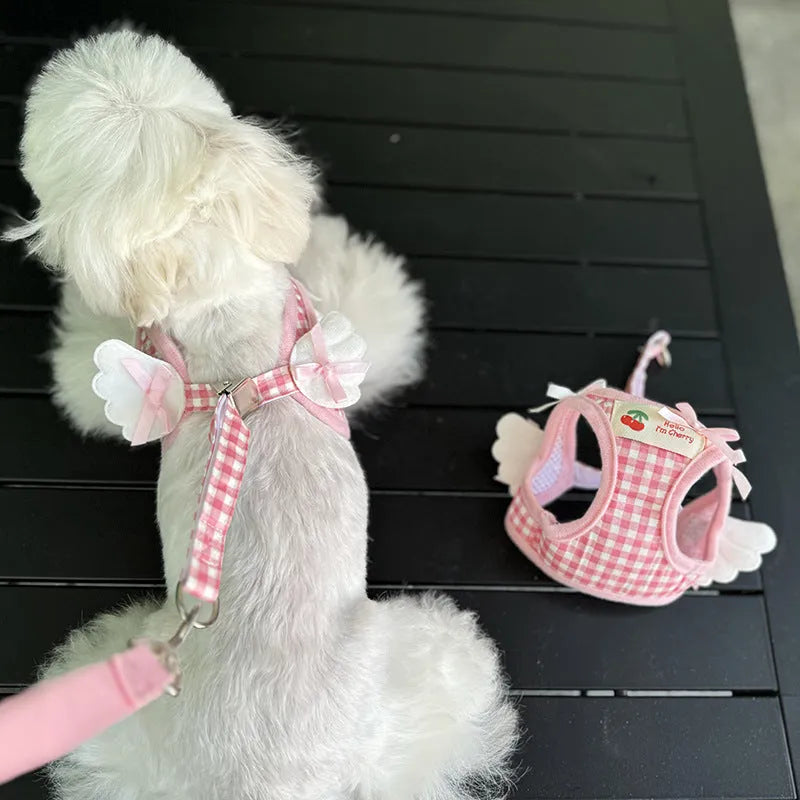 Pink and black cotton chest and back hand holding rope harness for a small dog on a white background.