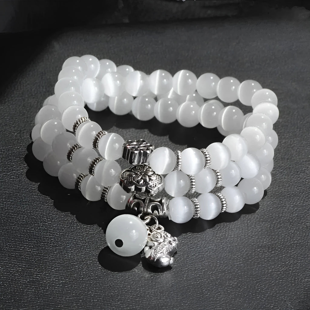 Women's opal bracelet with lucky cat charm, shown in a triple-wrap style with colourful geometric beads.