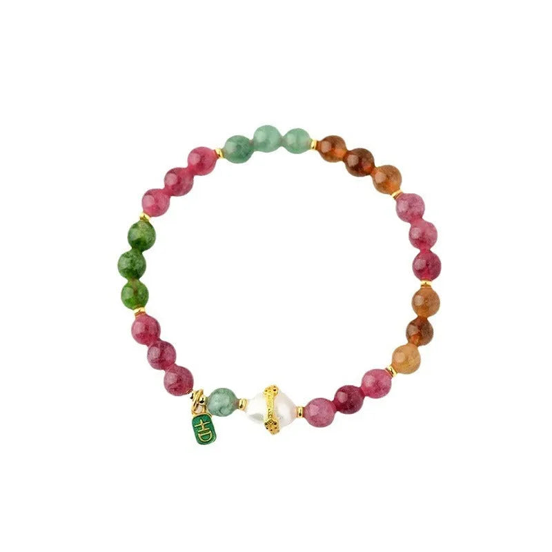 Close-up of a chalcedony bracelet with geometric 6.5mm beads in a tourmaline colour on a wrist.