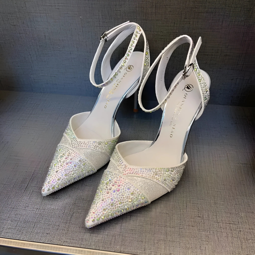 Women's black stiletto high heel with pointed toe and red sole, shown from the side.