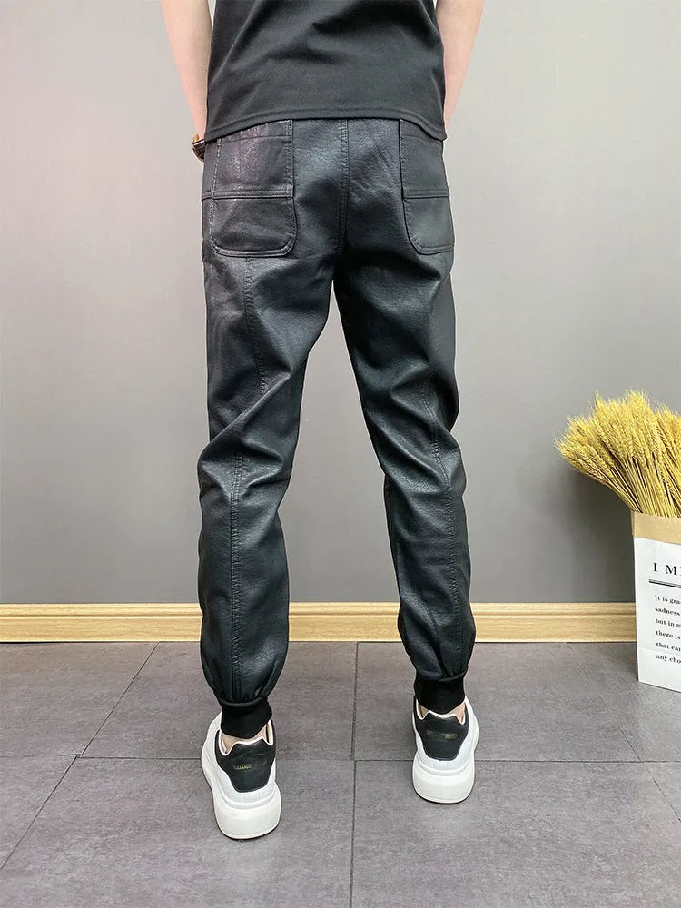 Black slim-fit waterproof motorcycle trousers in artificial leather with mid-rise waist and tapered leg