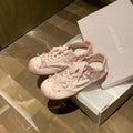Women's champagne pink satin ballet flats with front lace-up and round toe on a white background.
