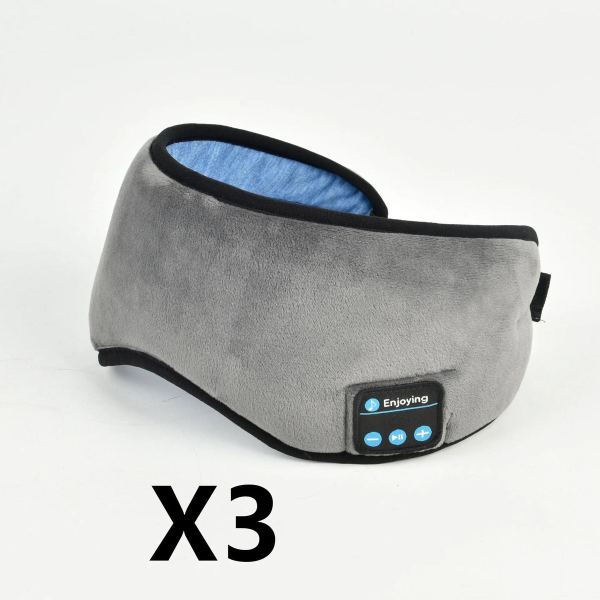 Soft satin sleep eye mask in black with adjustable strap lying flat on a light background